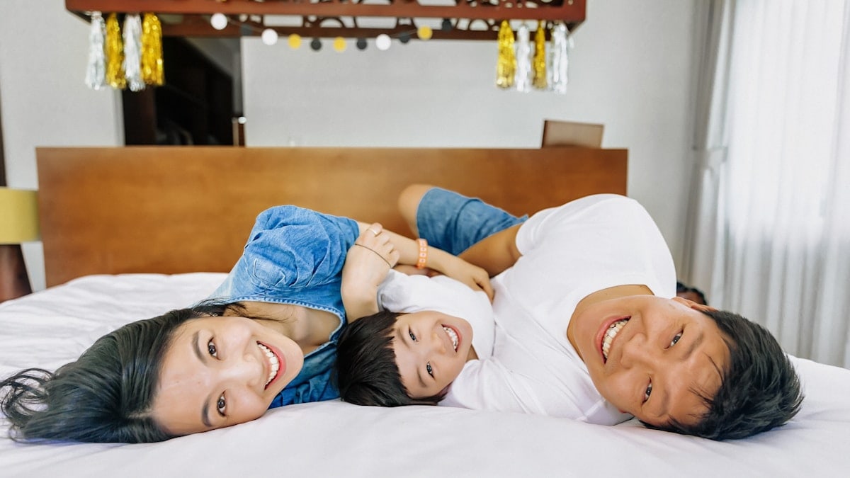 Happy couple relaxing together in bed at home, cozy morning lifestyle moment.